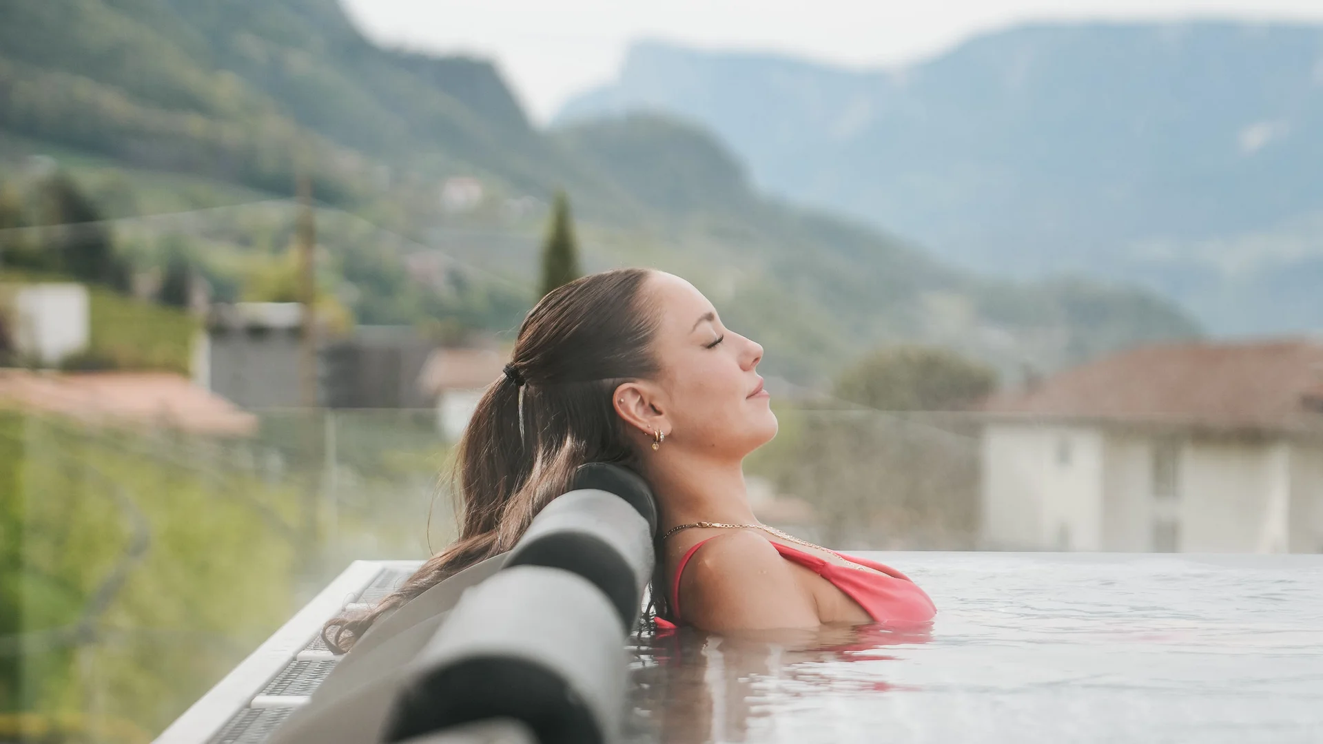 Euer Hotel in Schenna für Momente in #echtzeit Frau entspannt im beheizten Außenpool mit Bergblick